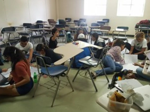 students in a classroom working on the floor
