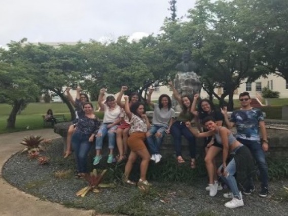 students sitting on a rock wall group photo