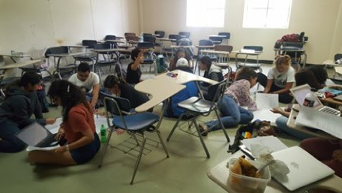 students in a classroom working on the floor