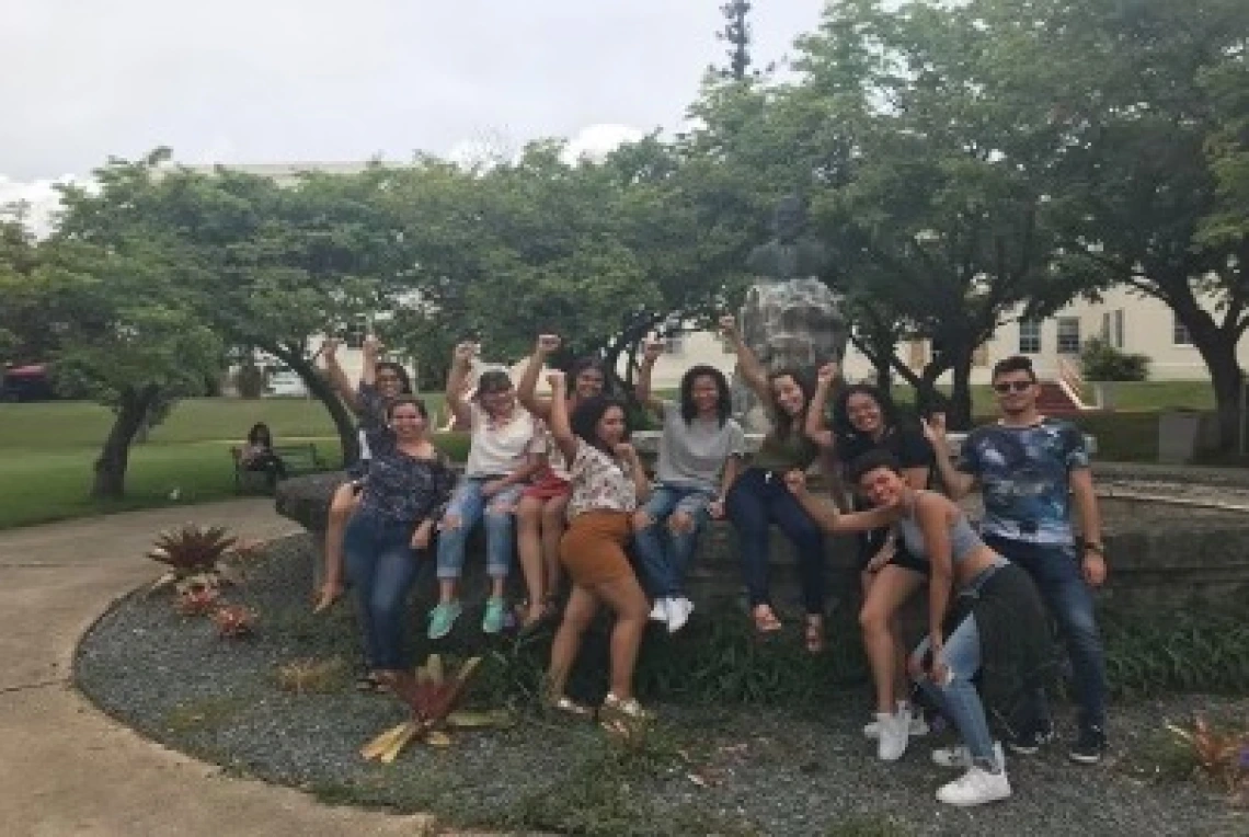 students sitting on a rock wall group photo